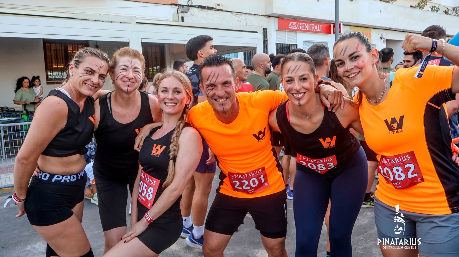 El entrenador y alumnas de Wolf Fitness sonriendo con la cara pintada antes de competir